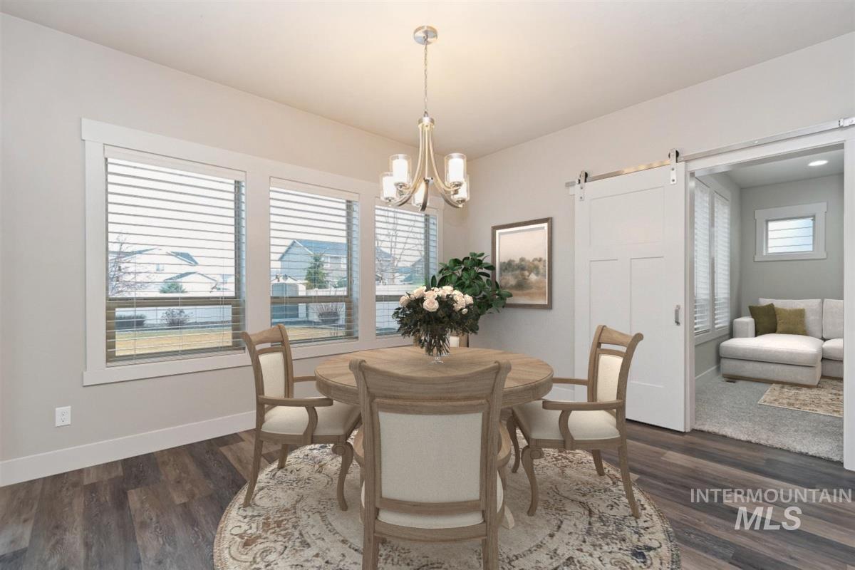 9580 West Ringle Creek Street Star, ID 83669 - Photo 20 of 43 Dining room featuring a barn door, dark wood-type flooring, and hanging lights