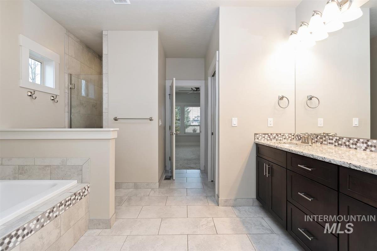 9580 West Ringle Creek Street Star, ID 83669 - Photo 26 of 43 Bathroom with vanity, a tile shower, a bath, light tile patterned floors, and a ceiling fan