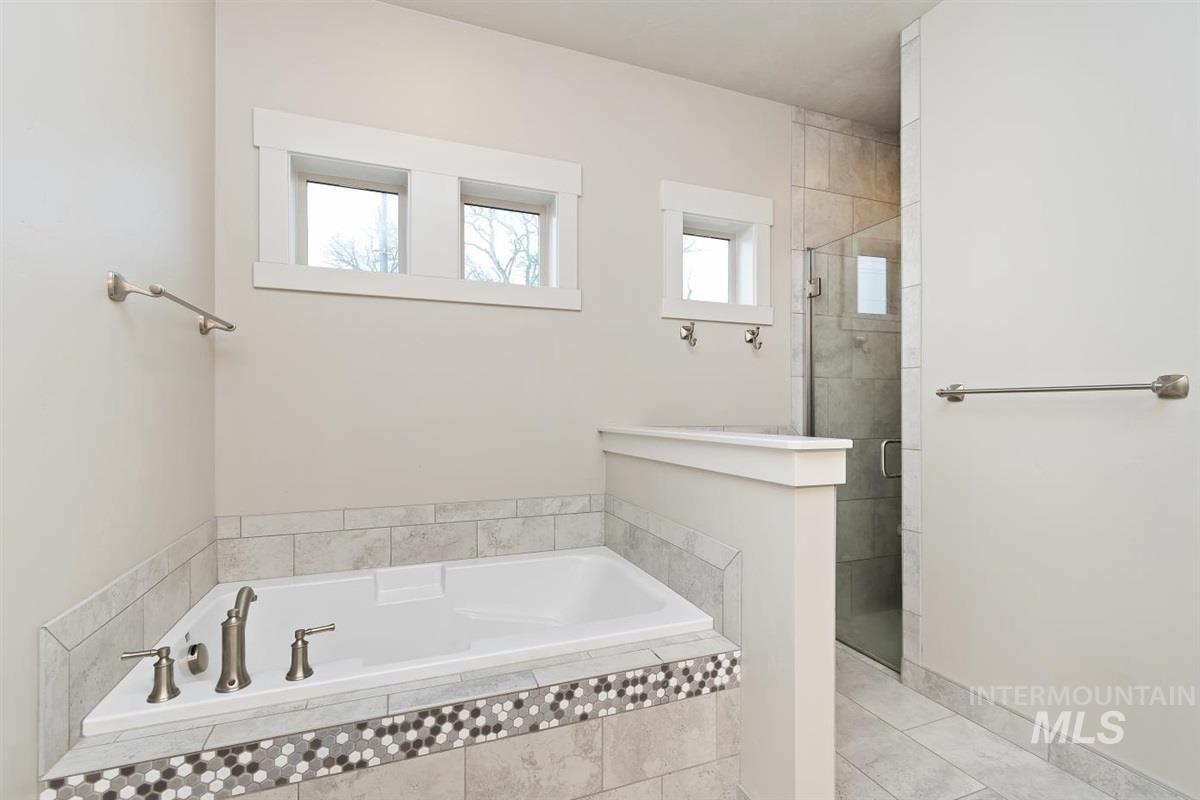 9580 West Ringle Creek Street Star, ID 83669 - Photo 28 of 43 Full bathroom with plenty of natural light, a shower stall, a garden tub, and light tile patterned floors