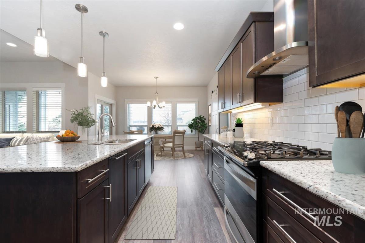 9580 West Ringle Creek Street Star, ID 83669 - Photo 8 of 43 Kitchen featuring dark wood finish cabinets, stainless steel appliances, light stone counters, light wood-type flooring, and backsplash