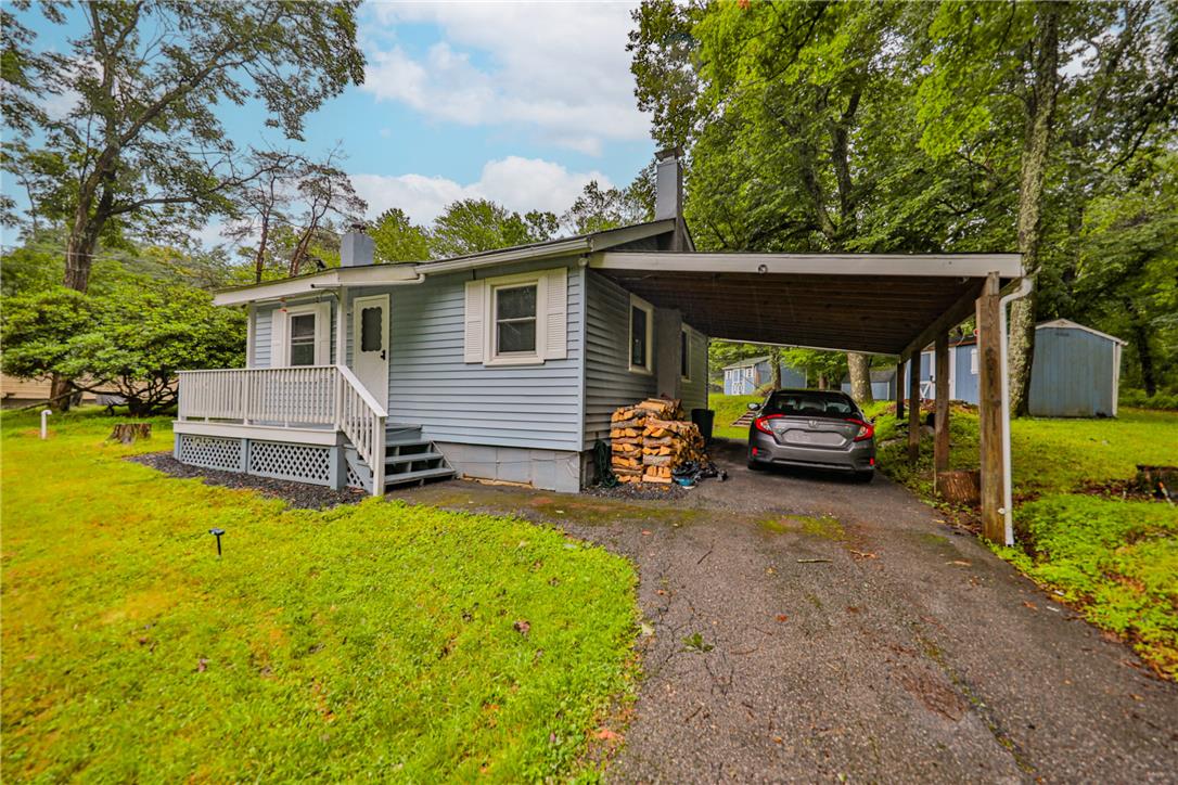5599 Minks Pond Road Bushkill, PA 18324 - Photo 31 of 64 A charming cottage-style residence features a covered carport and front porch, set amidst a verdant, mature treed lot.