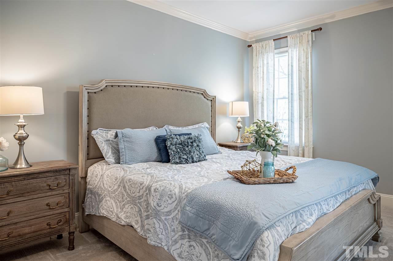6208 Hampton Ridge Road Raleigh, NC 27603 - Photo 21 of 30 a bedroom with a bed and a potted plant