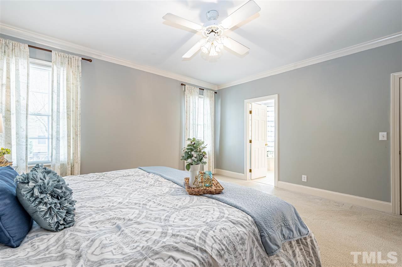 6208 Hampton Ridge Road Raleigh, NC 27603 - Photo 22 of 30 a bedroom with a large bed and a chandelier