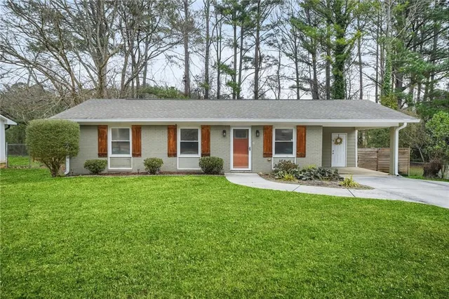 a front view of a house with a yard and trees