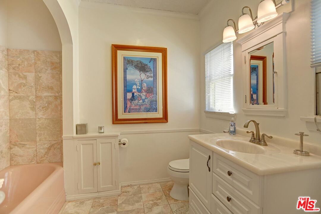 602 North Camden Drive Beverly Hills, CA 90210 - Photo 13 of 18 a bathroom with a sink mirror and a bathtub