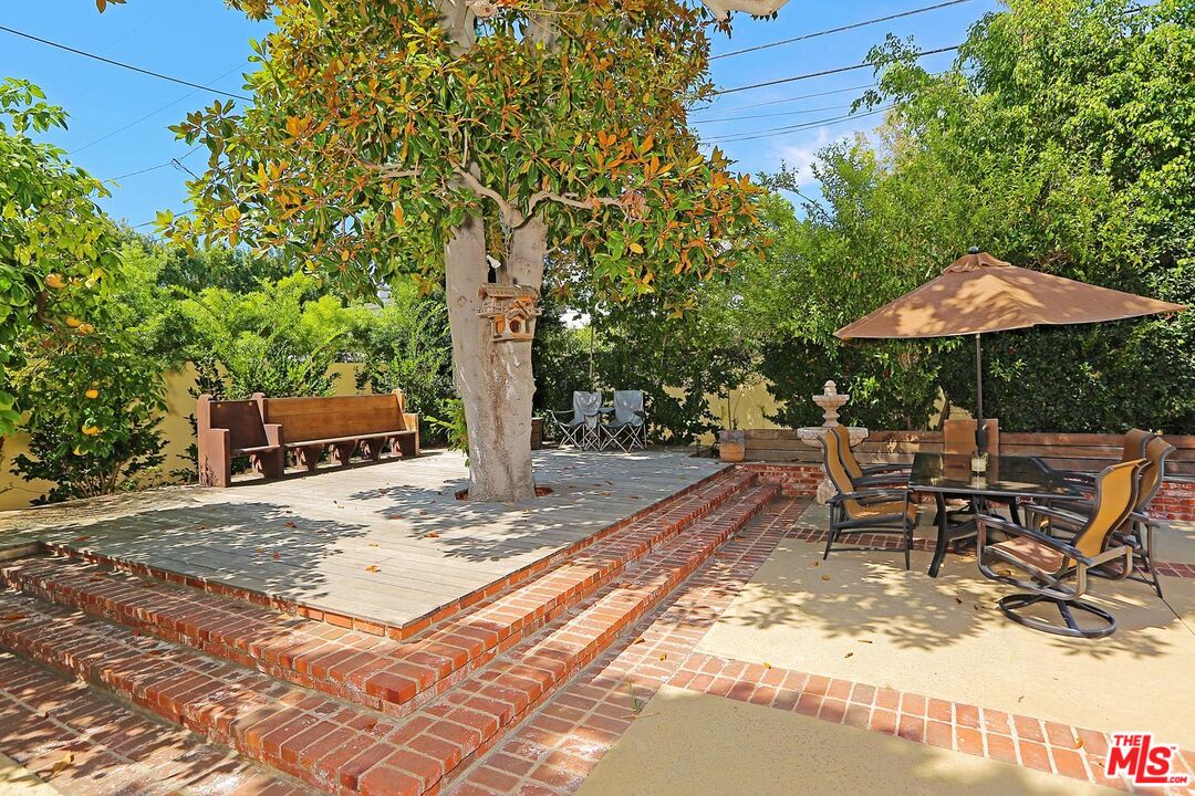 602 North Camden Drive Beverly Hills, CA 90210 - Photo 17 of 18 a patio with table and chairs under an umbrella