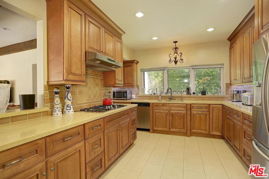 602 North Camden Drive Beverly Hills, CA 90210 - Photo 5 of 18 a kitchen with sink a stove and cabinets