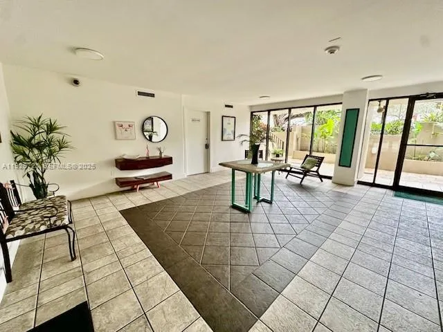 a view of a refrigerator in kitchen and an empty room in wooden floor