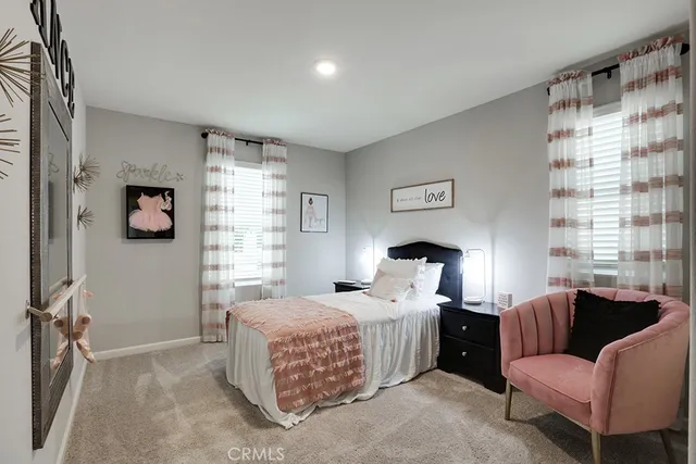 a bedroom with a bed couch and a window