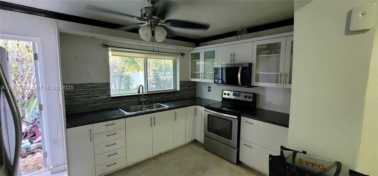 a kitchen with granite countertop a sink stainless steel appliances a counter space and cabinets