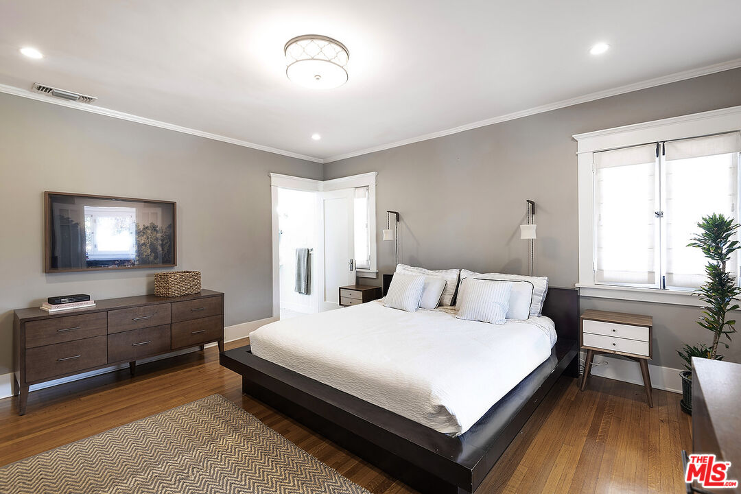 1927 Buckingham Road Los Angeles, CA 90016 - Photo 19 of 36 a bedroom with a bed and a chandelier