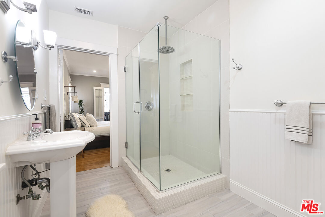 1927 Buckingham Road Los Angeles, CA 90016 - Photo 21 of 36 a bathroom with a shower a mirror and a sink