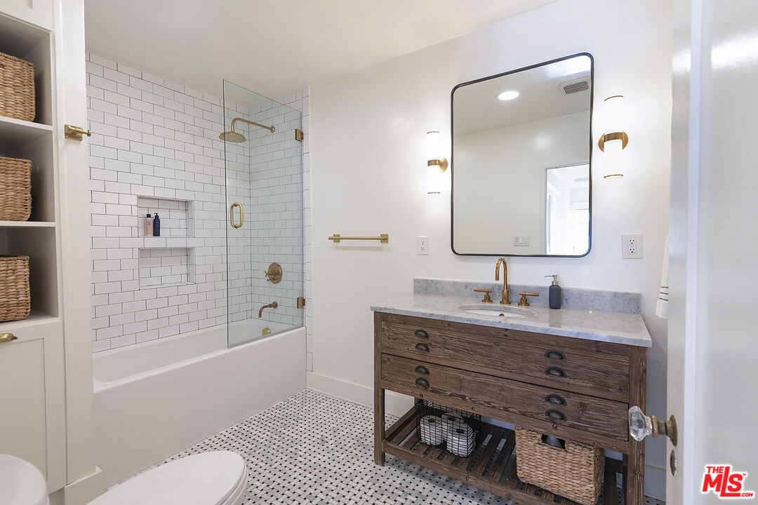 1927 Buckingham Road Los Angeles, CA 90016 - Photo 26 of 36 a bathroom with a granite countertop sink toilet a mirror a vanity and shower