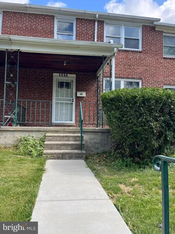 a view of brick house with a yard