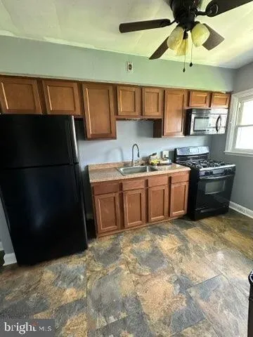 a kitchen with stainless steel appliances granite countertop a sink a stove and a refrigerator