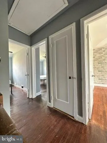 a view of a hallway with wooden floor and a livingroom view