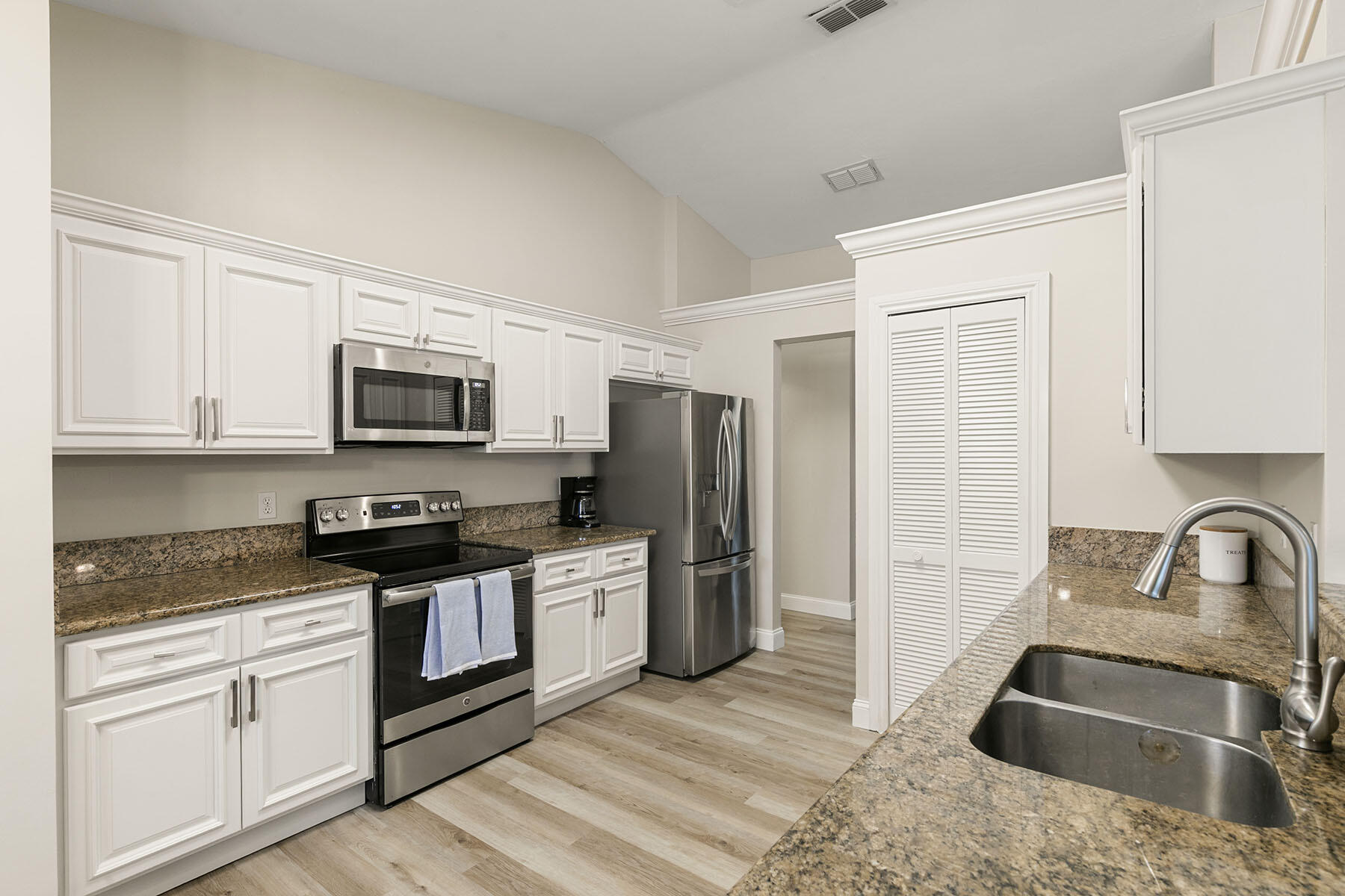 159 Plantation Circle Naples, FL 34104 - Photo 12 of 38 a kitchen with stainless steel appliances granite countertop a sink stove microwave and refrigerator
