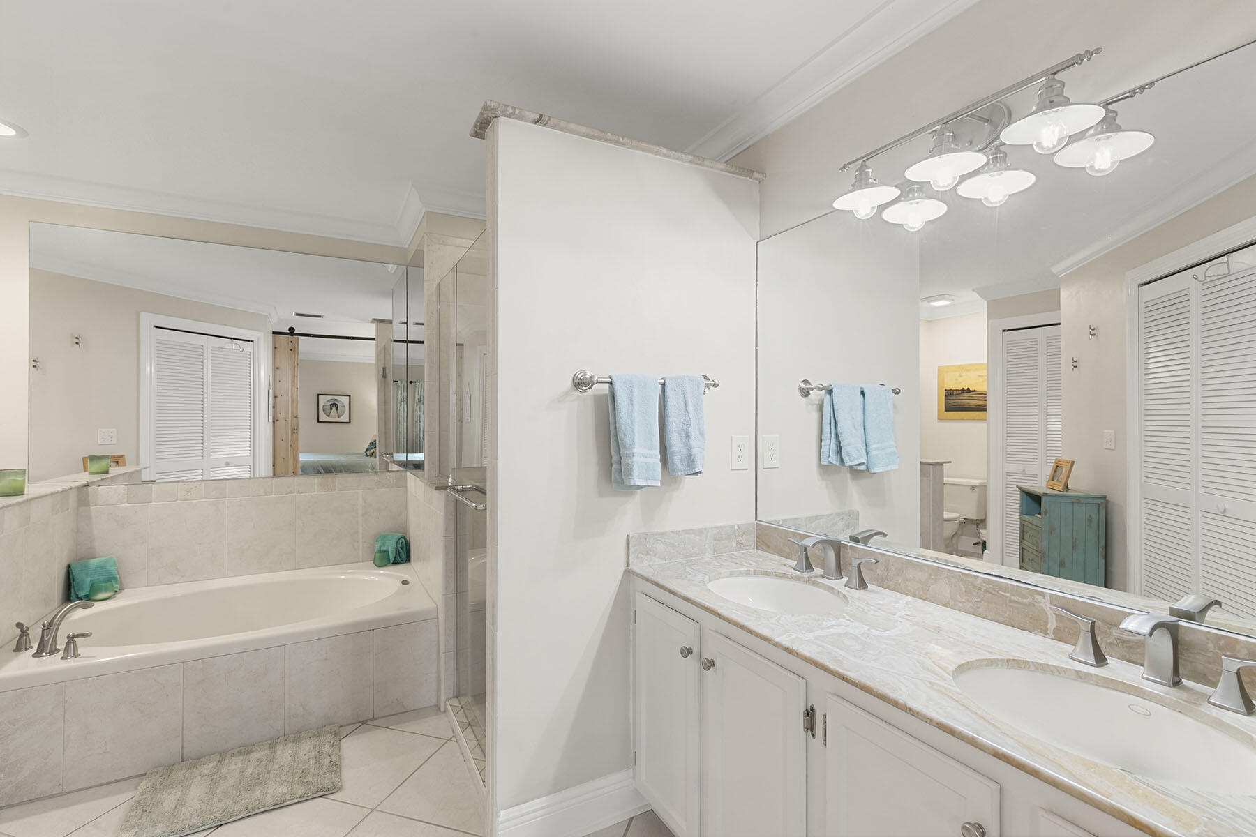 159 Plantation Circle Naples, FL 34104 - Photo 19 of 38 a bathroom with a tub a sink and mirror