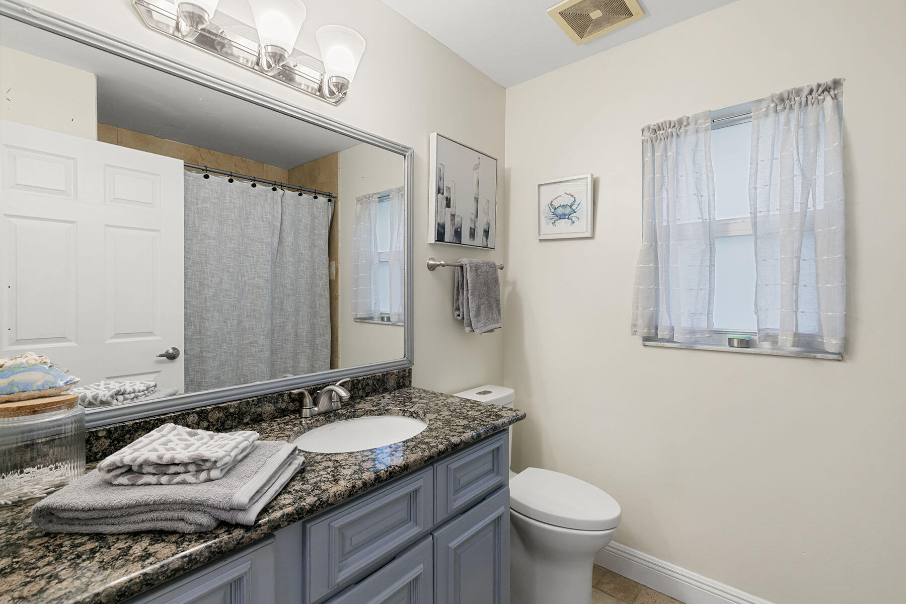159 Plantation Circle Naples, FL 34104 - Photo 23 of 38 a bathroom with a granite countertop sink a toilet and a mirror