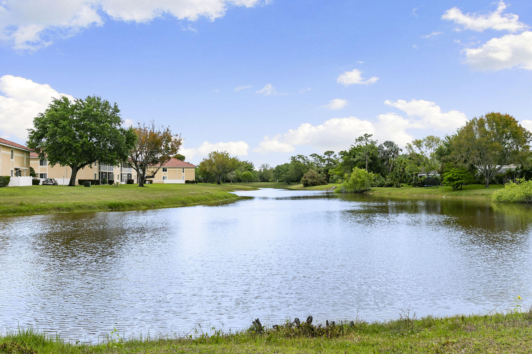 159 Plantation Circle Naples, FL 34104 - Photo 3 of 38 a view of a lake with houses in the background