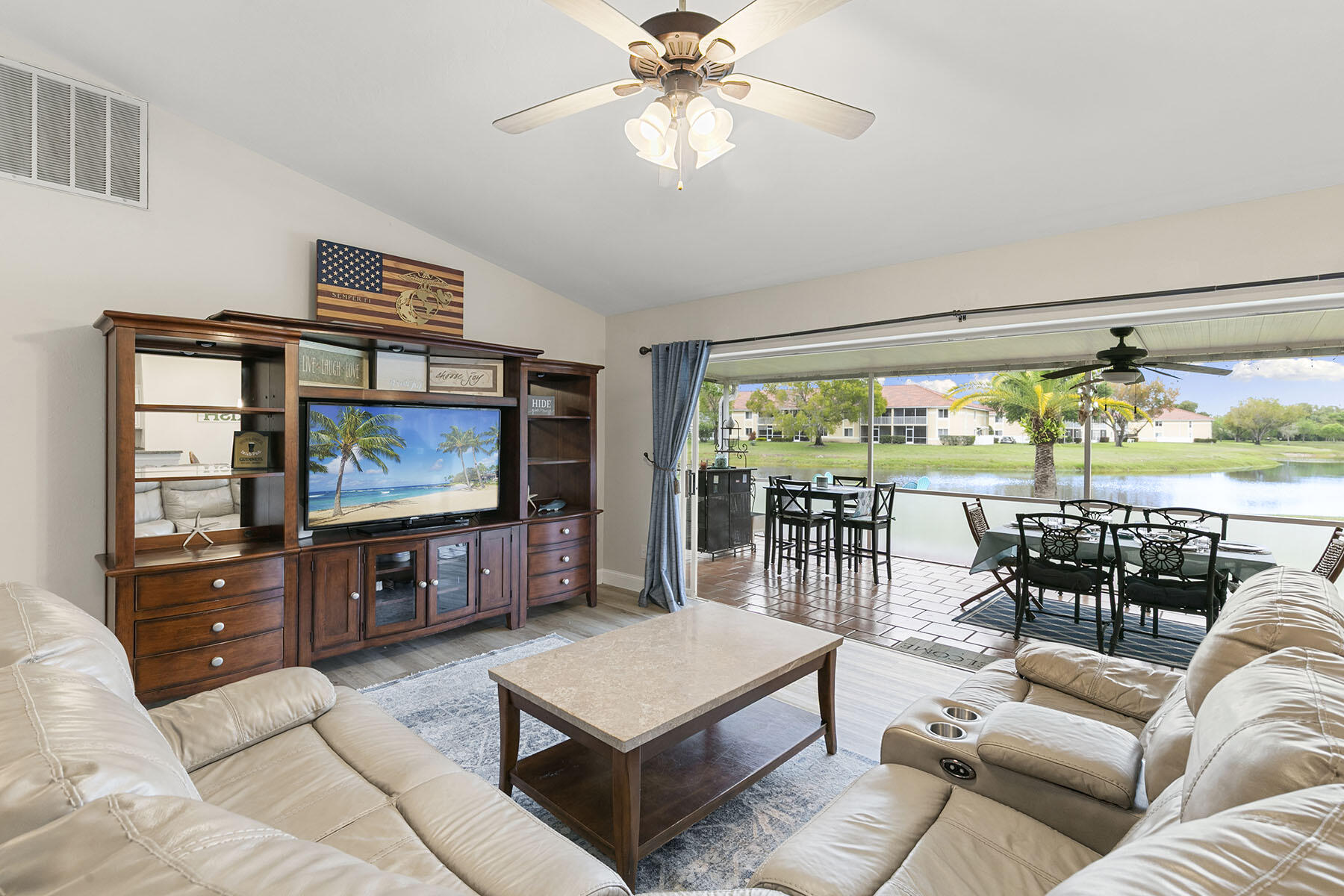 159 Plantation Circle Naples, FL 34104 - Photo 5 of 38 a living room with furniture a flat screen tv and a large window