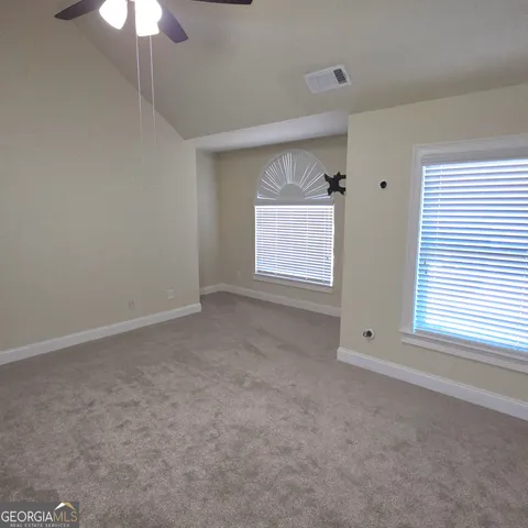 an empty room with closet and a ceiling fan