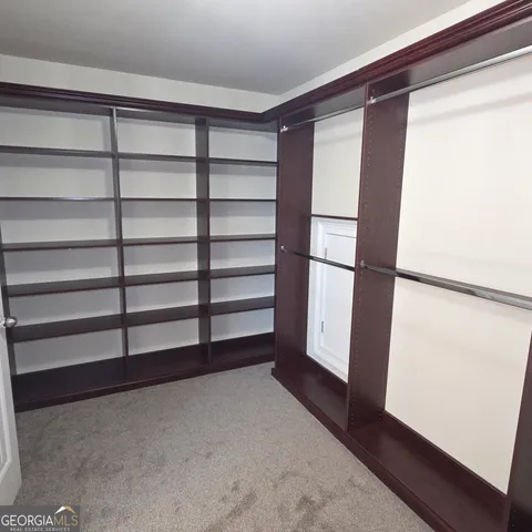 a view of a big house with a yard and lawn chairs