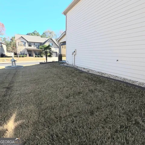 a view of a house with a large space and a road