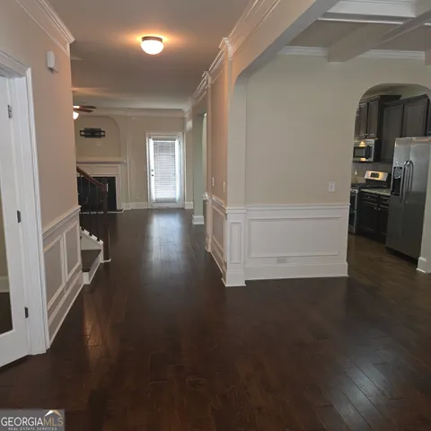 a view of a hallway with wooden floor fireplace and windows