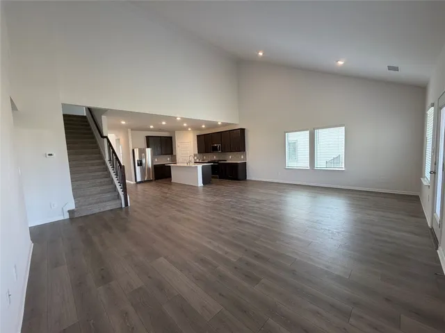 a view of a livingroom with wooden floor and staircase