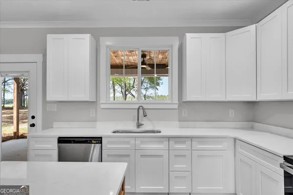 a kitchen with granite countertop white cabinets and white appliances