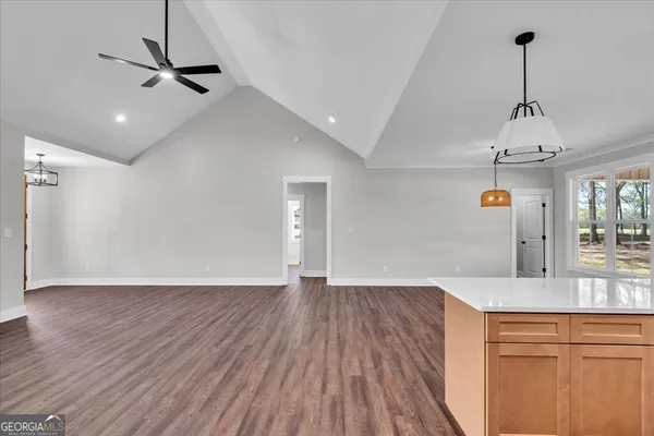 a view of empty room with wooden floor and ceiling fan