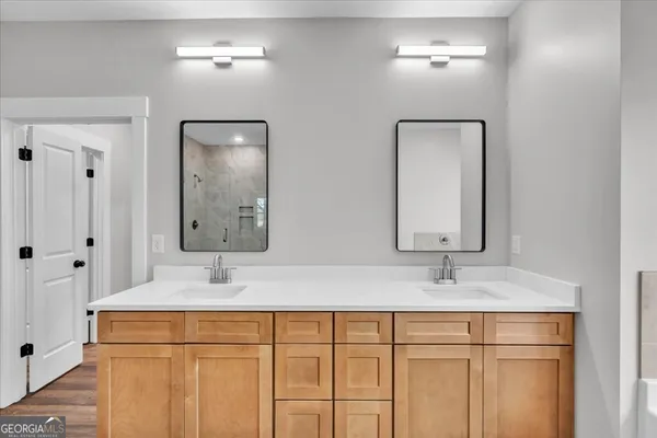 a bathroom with double vanity sink and a mirror
