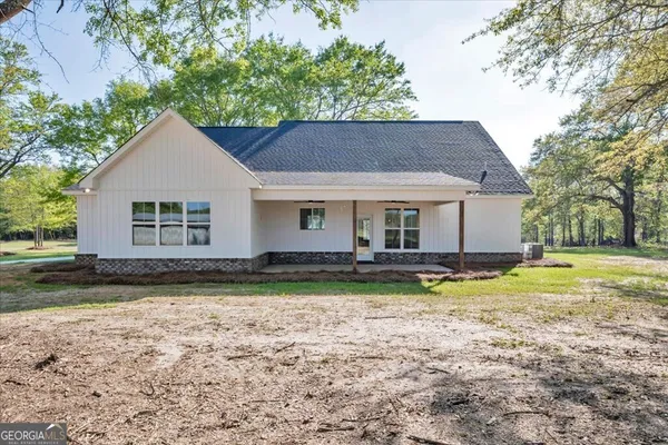 a view of a house with garden and trees in the background