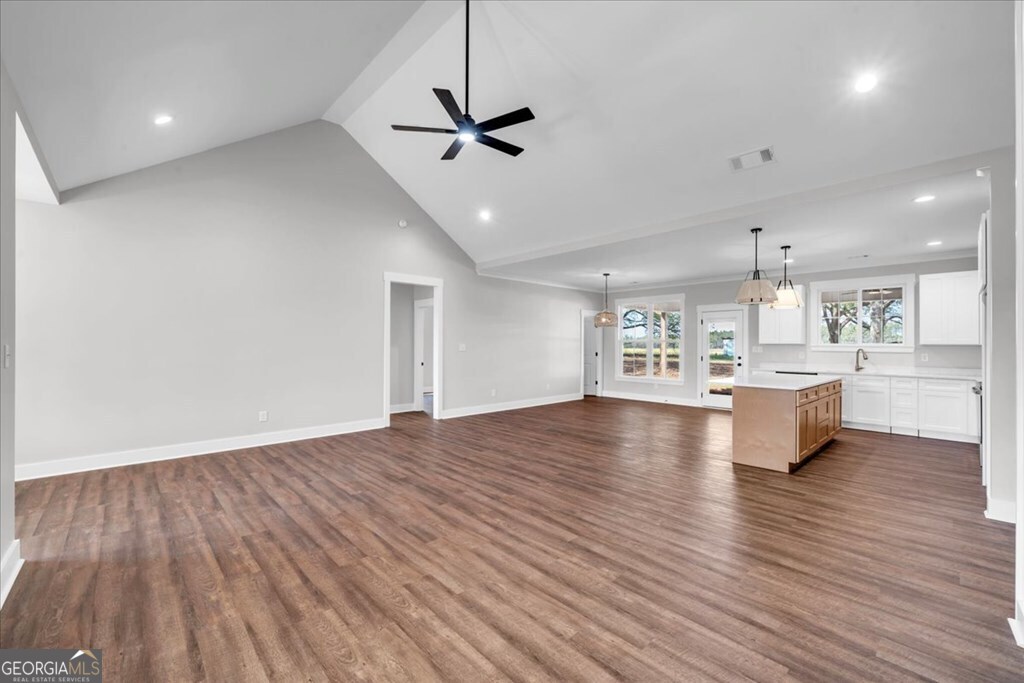 2769 Claxton Dairy Road Dublin, GA 31021 - Photo 4 of 48 a view of an empty room and kitchen with wooden floor