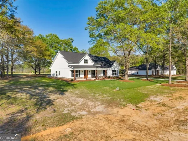 a front view of a house with sitting area and garden