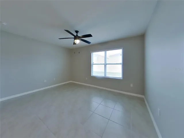 an empty room with a window and a fan