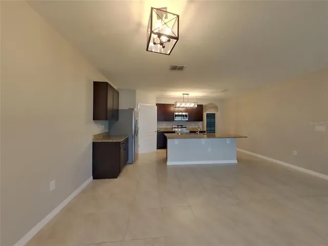 a view of kitchen with sink microwave and refrigerator