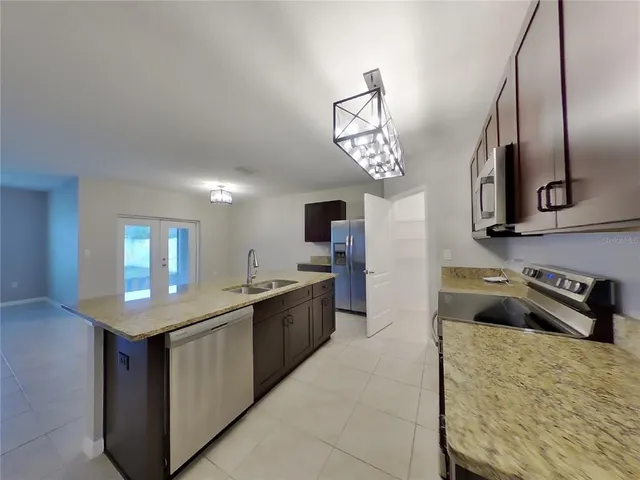a kitchen with stainless steel appliances granite countertop a sink stove and refrigerator
