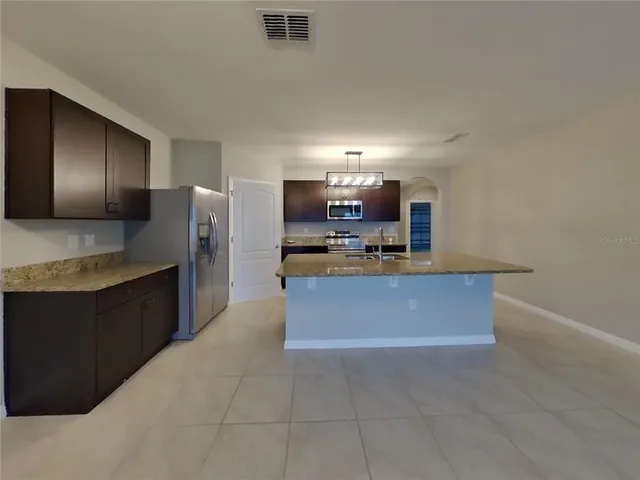 a large kitchen with stainless steel appliances a refrigerator and a stove