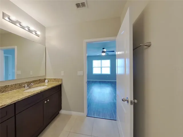 a spacious bathroom with a granite countertop sink and a mirror