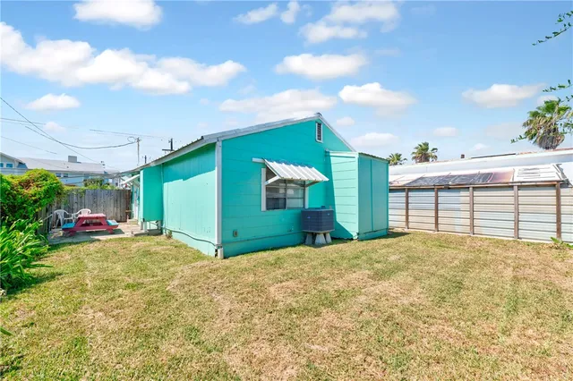 a view of a livingroom with a chandelier fan and windows