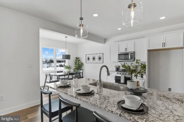 a living room with furniture a flat screen tv and kitchen view