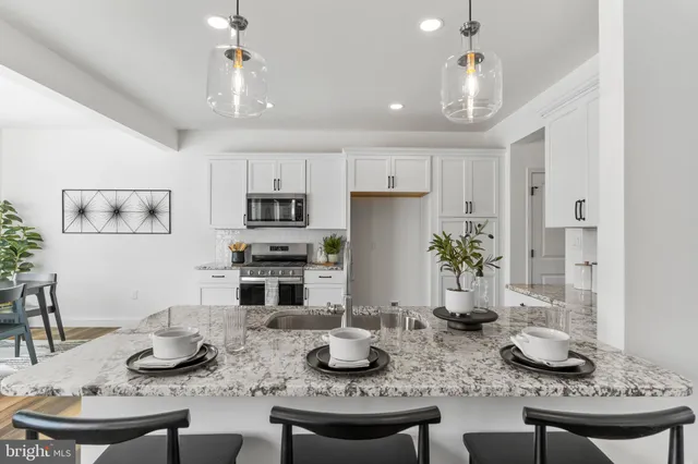 a kitchen with stainless steel appliances granite countertop a stove a microwave and sink