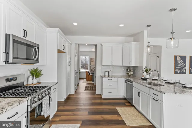 a kitchen with granite countertop white cabinets and a sink