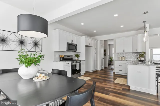 a living room with furniture potted plant and kitchen view