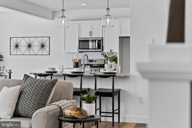 a living room with furniture a rug and a wall painting
