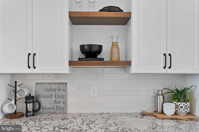 a vase of flowers besides a sink and a mirror