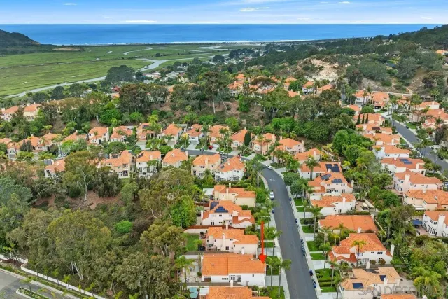 an aerial view of residential houses with outdoor space and trees