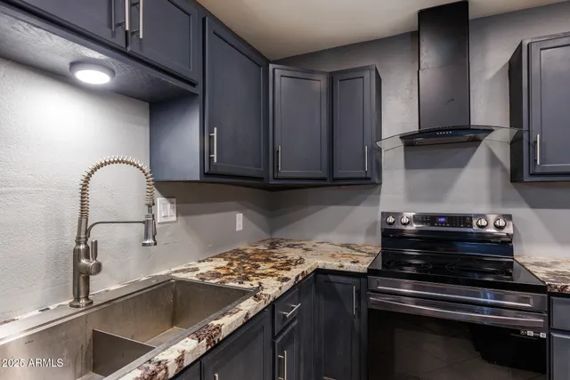 a kitchen with granite countertop a stove and a sink